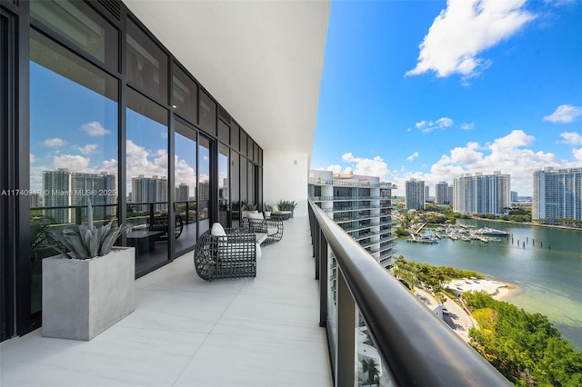 balcony featuring a water view and a city view