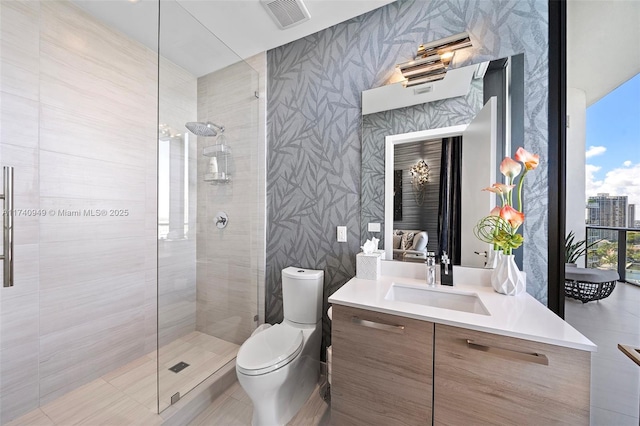 bathroom with visible vents, a tile shower, and wallpapered walls