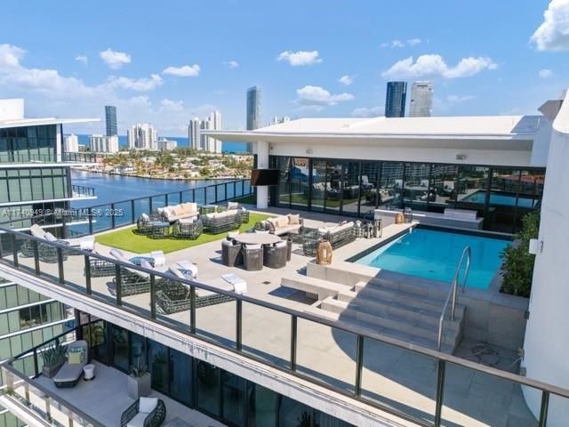 pool featuring a city view, an outdoor hangout area, a patio, and a water view