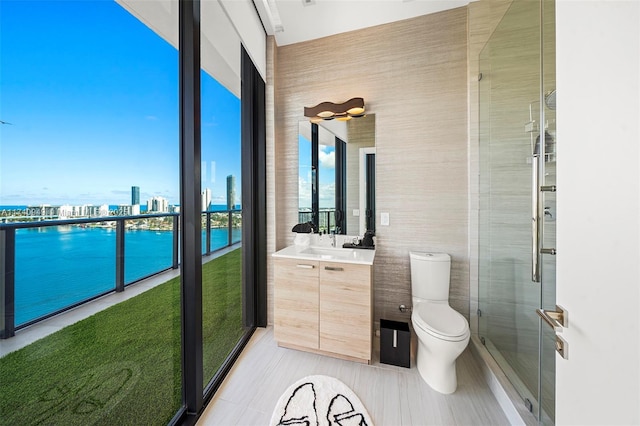 bathroom with a city view, vanity, tile patterned flooring, toilet, and tile walls