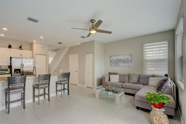 living room with light tile patterned floors and ceiling fan