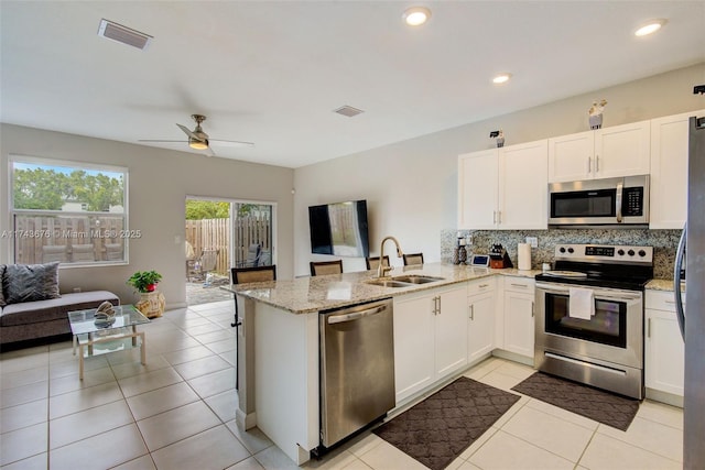 kitchen with white cabinetry, sink, kitchen peninsula, and appliances with stainless steel finishes