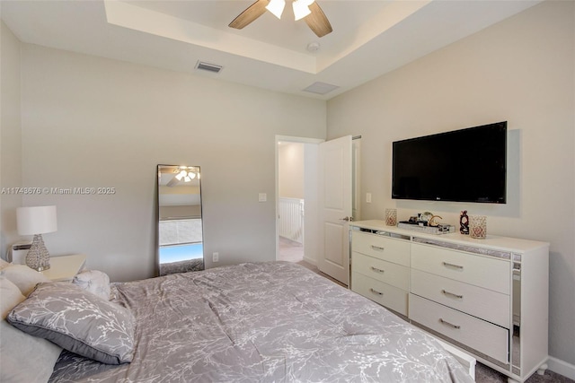 bedroom with a raised ceiling and ceiling fan