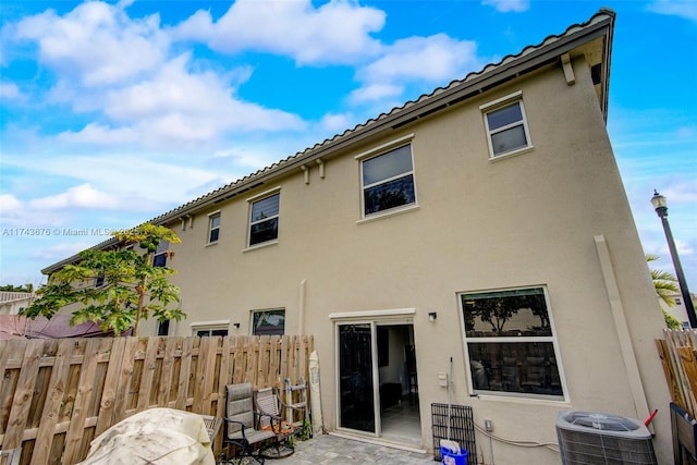 rear view of property featuring central AC unit and a patio area