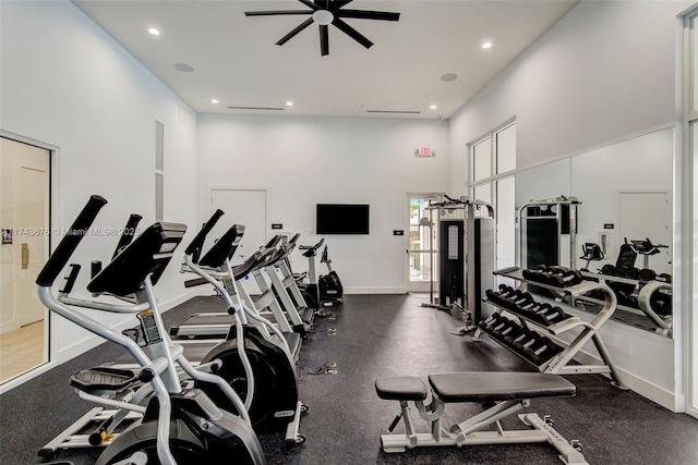 workout area with a towering ceiling and ceiling fan