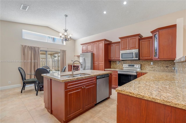 kitchen featuring an island with sink, lofted ceiling, hanging light fixtures, stainless steel appliances, and sink