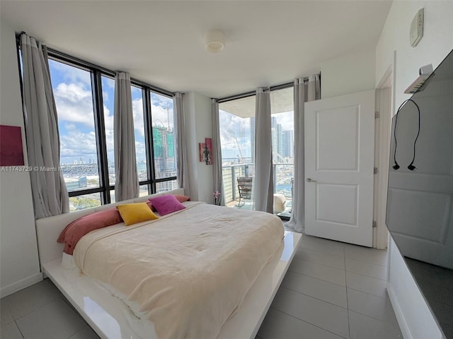 bedroom with light tile patterned floors, access to exterior, and baseboards