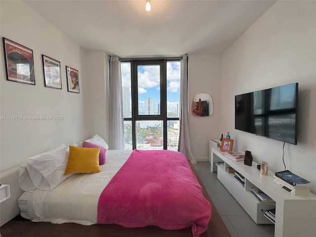 tiled bedroom with multiple windows and a wall of windows