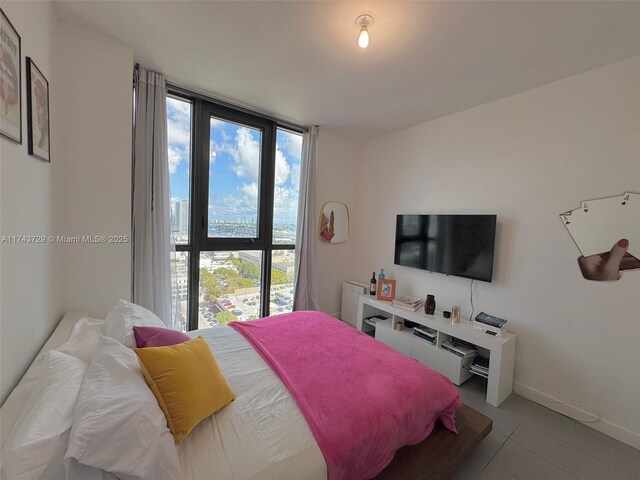 bedroom featuring light tile patterned floors and a wall of windows