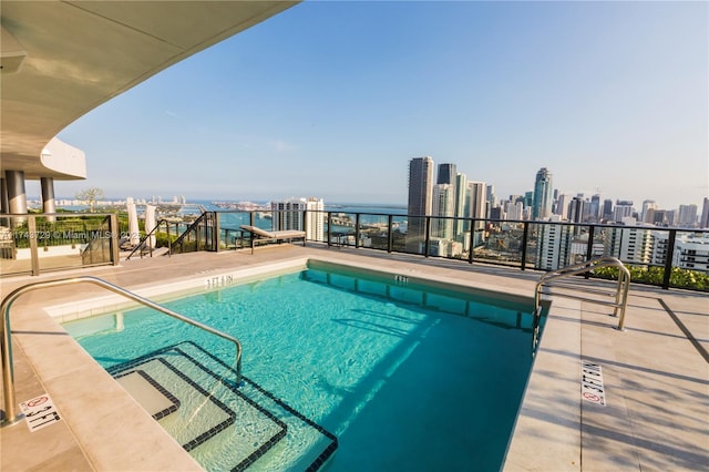 view of pool with a pool and a city view