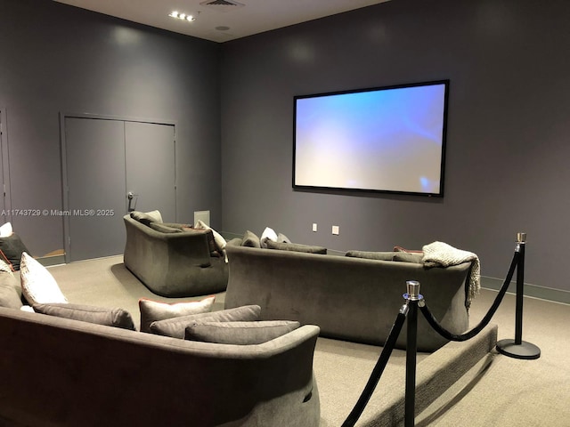 carpeted cinema room featuring visible vents and baseboards
