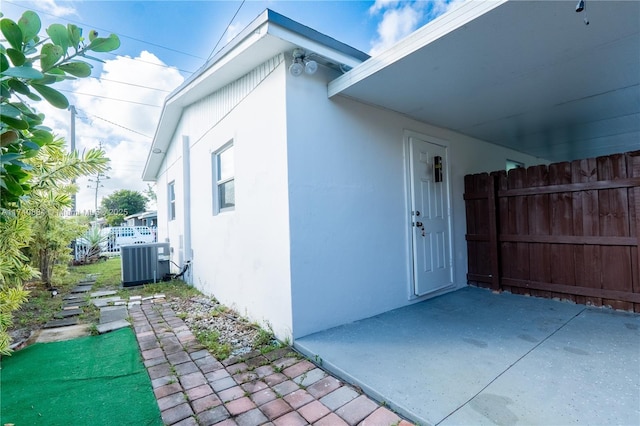 exterior space with cooling unit, a patio, fence, and stucco siding