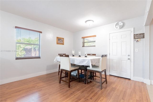 dining room with light wood-type flooring, baseboards, and a wealth of natural light