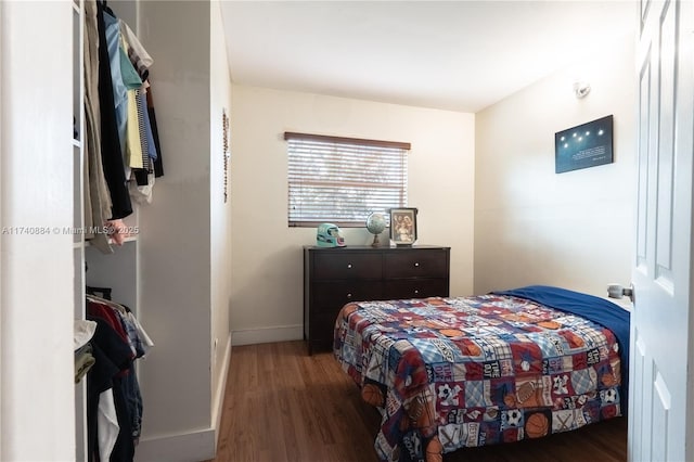 bedroom with dark wood finished floors and baseboards