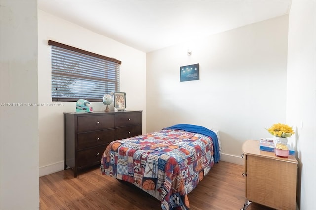 bedroom featuring baseboards and wood finished floors