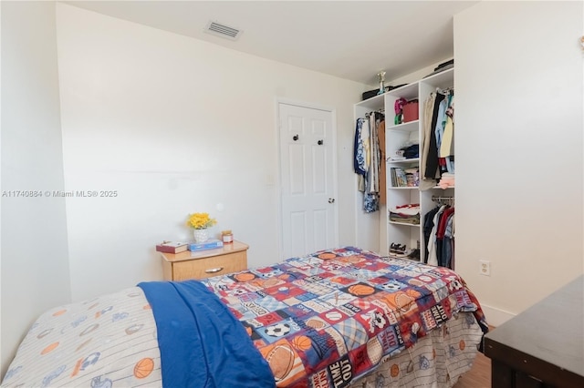 bedroom featuring a closet, wood finished floors, and visible vents