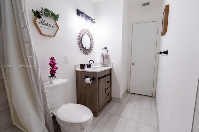 bathroom with toilet, vanity, visible vents, and tile patterned floors