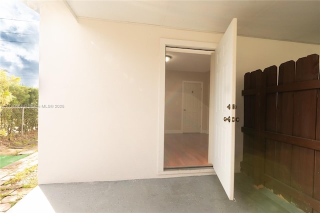 entrance to property with fence and stucco siding