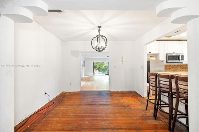 dining room featuring dark wood-type flooring and an inviting chandelier