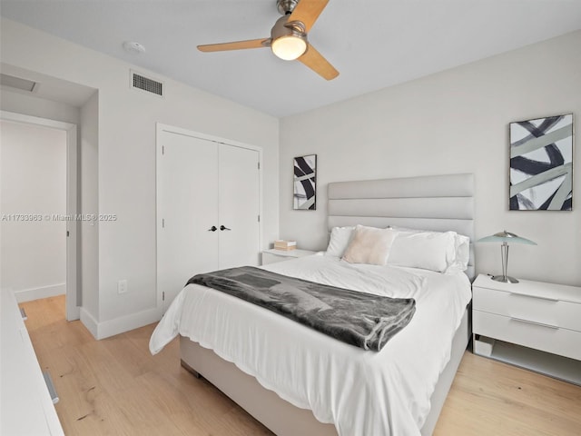 bedroom with ceiling fan, a closet, and light hardwood / wood-style flooring