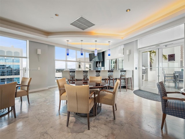 tiled dining room featuring a tray ceiling