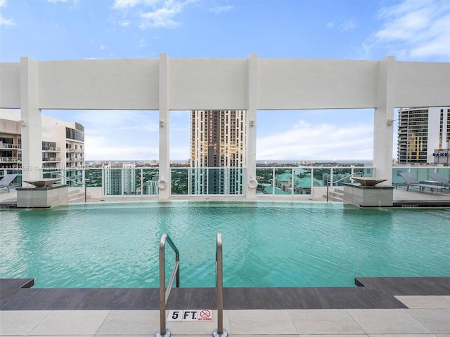 view of swimming pool with a water view and pool water feature