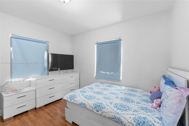 bedroom with dark hardwood / wood-style flooring