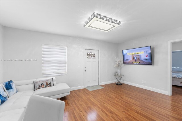 living area featuring baseboards and wood finished floors