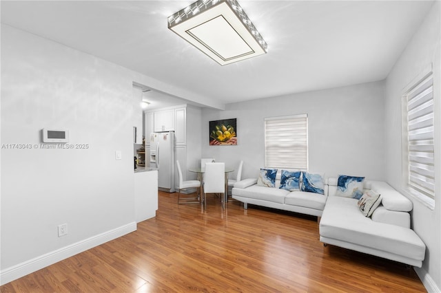 living area featuring light wood-style flooring and baseboards