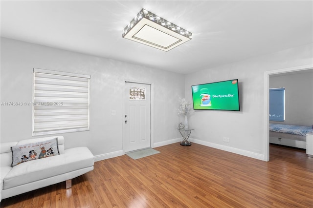 foyer entrance with wood finished floors and baseboards