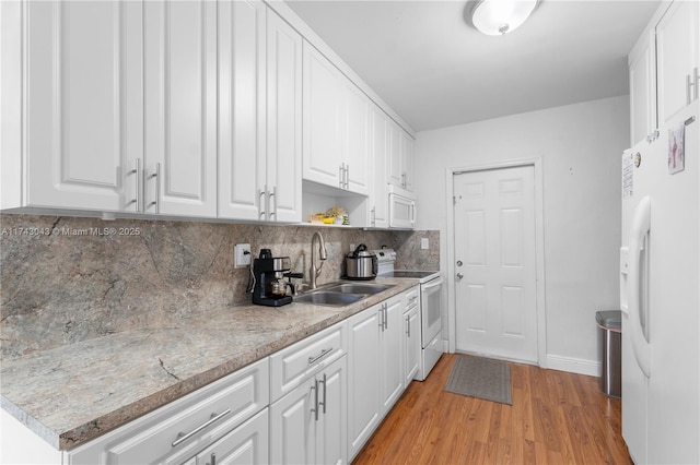 kitchen featuring sink, white cabinets, white appliances, light hardwood / wood-style floors, and backsplash