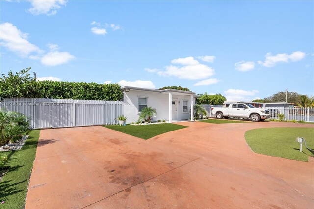 view of front facade featuring a front yard, fence, and stucco siding