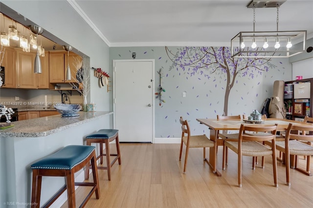 dining space featuring crown molding and light hardwood / wood-style floors