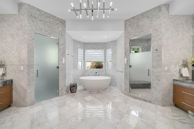 bathroom with tile walls, vanity, and independent shower and bath