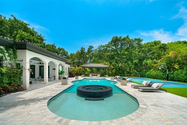 view of swimming pool with a patio area and an in ground hot tub