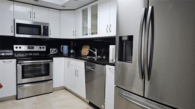 kitchen with white cabinetry, appliances with stainless steel finishes, sink, and decorative backsplash