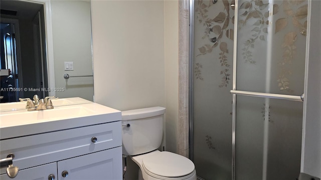 bathroom featuring toilet, vanity, and walk in shower