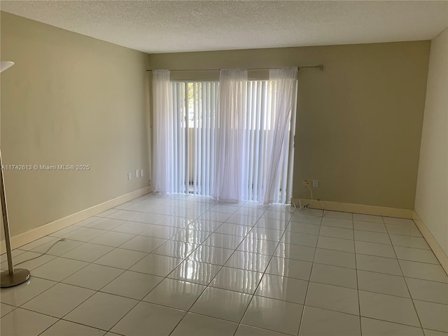 unfurnished room featuring light tile patterned floors and a textured ceiling