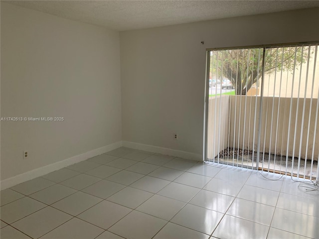 tiled empty room with a textured ceiling