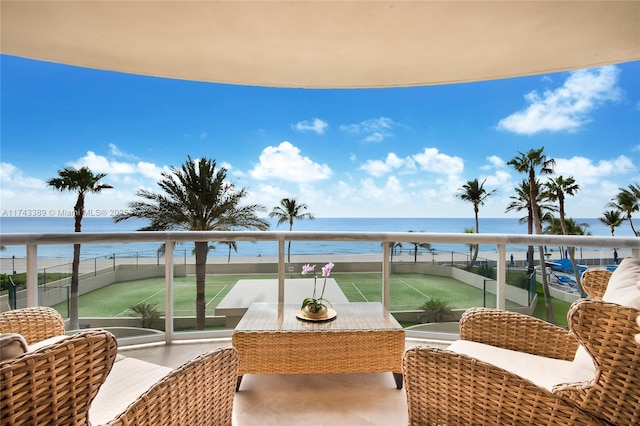 balcony with a water view and a beach view