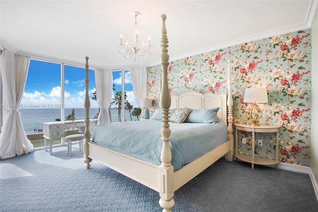 carpeted bedroom with a water view, an inviting chandelier, access to outside, ornamental molding, and a wall of windows