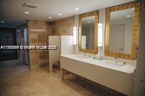 bathroom featuring vanity and tile walls