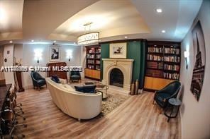 living room with a raised ceiling and hardwood / wood-style flooring