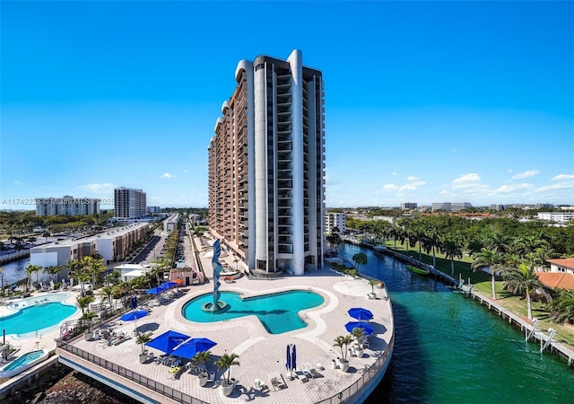 view of pool with a water view and a patio