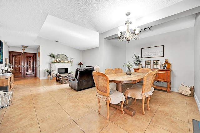 tiled dining area featuring a chandelier and a textured ceiling