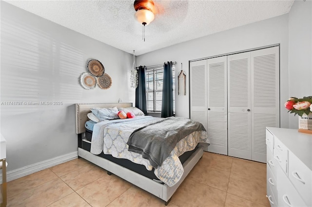 tiled bedroom featuring ceiling fan, a closet, and a textured ceiling