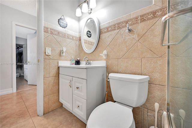 bathroom featuring vanity, toilet, tile patterned flooring, and tile walls