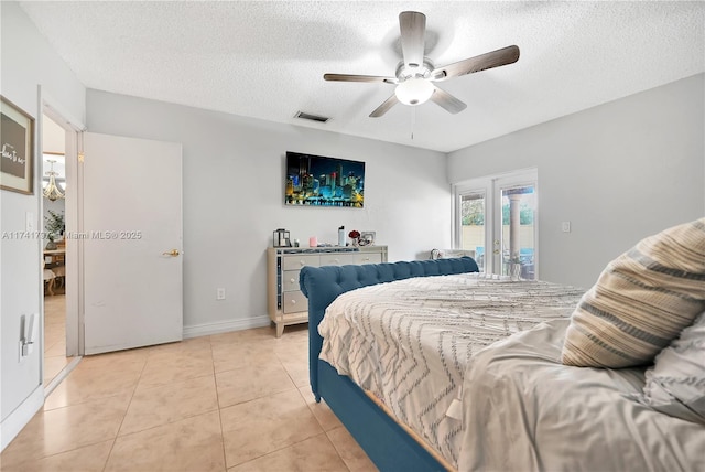 tiled bedroom featuring ceiling fan, access to exterior, a textured ceiling, and french doors