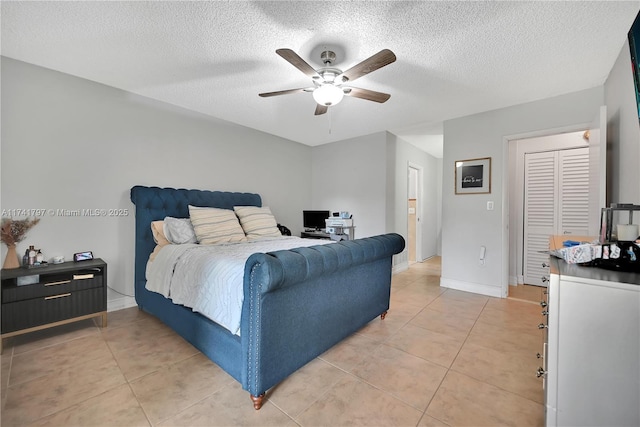 tiled bedroom with ceiling fan and a textured ceiling