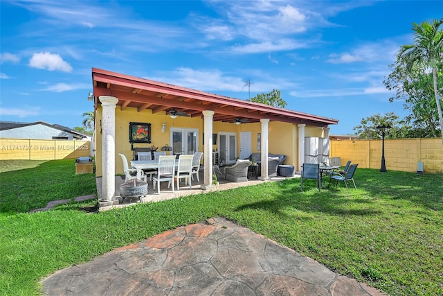 back of property featuring french doors, a patio area, a yard, outdoor lounge area, and ceiling fan